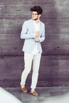 Portrait of cheerful trendy guy with black eyeglasses on wearing blue blazer jacket