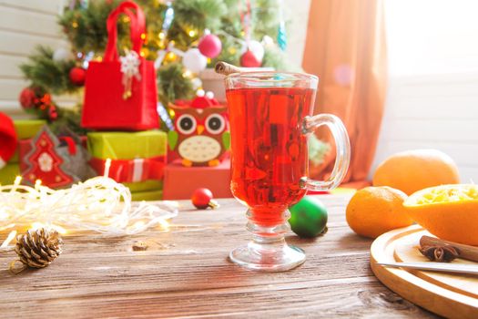 Mulled wine with spices on wooden background.