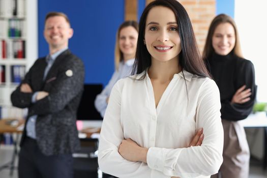 Portrait of woman leader present her team, well dressed workers posing with crossed hands. Businesswoman proud of colleagues, employees follow boss. Business, teamwork, strategy concept