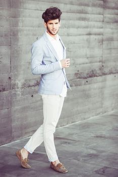 Portrait of a young handsome man, model of fashion, with modern hairstyle in urban background