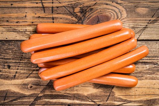 Raw frankfurter sausages on kitchen table. Wooden background. Top view.