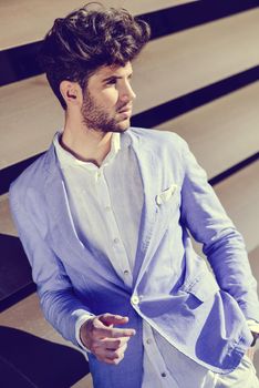 Portrait of a young handsome man, model of fashion, with modern hairstyle in urban background