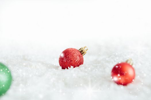 Christmas balls in the snow on white Beautiful Christmas bauble decorations lie on the white fluffy snow. Atmosphere of magic and fairy tales .