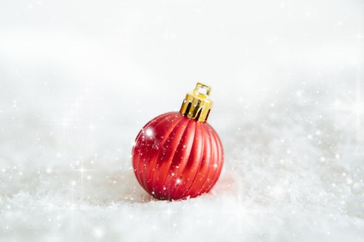 red christmas ball lying on snow Beautiful Christmas bauble decorations lie on the white fluffy snow. Atmosphere of magic and fairy tales .