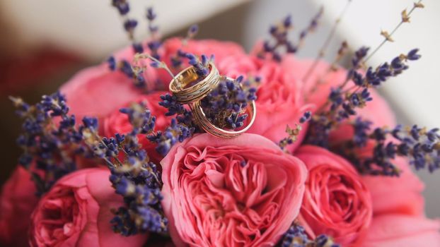 Golden wedding rings in center of bride's bouquet, close up