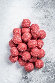 Raw beef and pork meatballs with spices on kitchen table. White background. Top view.