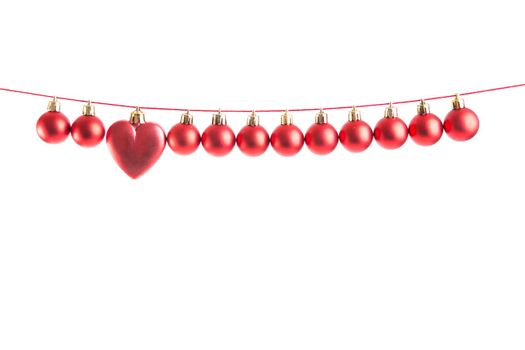 Line of red christmas balls and one heart shape christmas bauble on white background. Christmas decorations. .