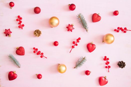 Pink wooden christmas background with red and gold color christmas decorations. View from above .
