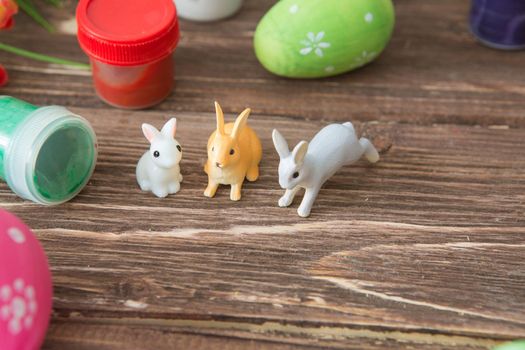 Easter eggs and Easter rabbits toys with flower on a wooden table. .