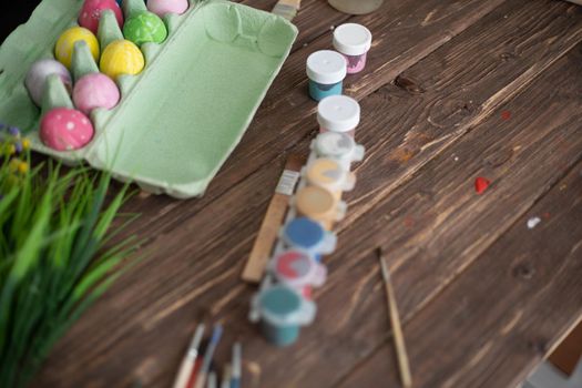 Table with paint and brush for painting easter eggs.