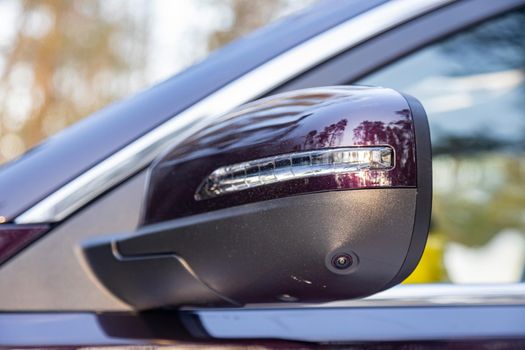 side mirror of the rear view of a modern car with a terrain view camera. close up. Parking assistant and car help systems.