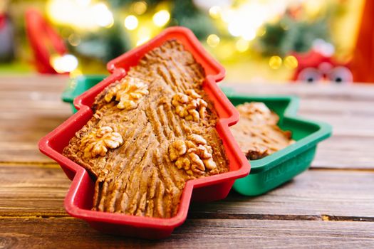 Homemade Christmas cake in the shape of a Christmas tree on a wooden table .