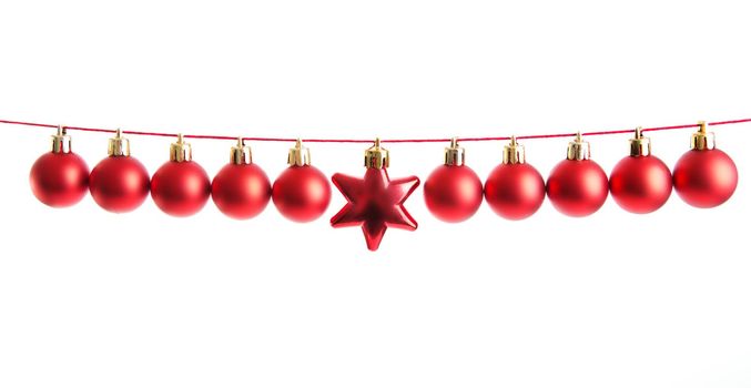 Line of red christmas balls and one star shape christmas bauble on white background. Christmas decorations. .