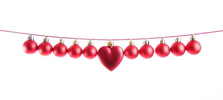 Line of red christmas balls and one heart shape christmas bauble on white background. Christmas decorations. .