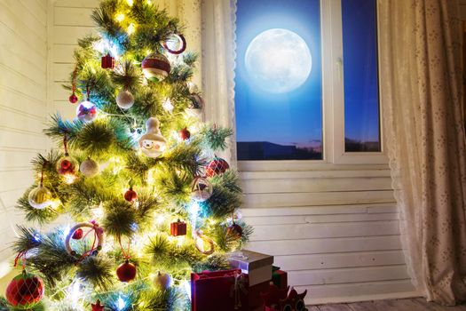 Christmas home room with tree and moon lighting in window. The elements of this image furnished by NASA.