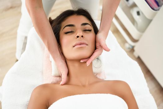 Arab woman receiving head massage in spa wellness center. Beauty and Aesthetic concepts.