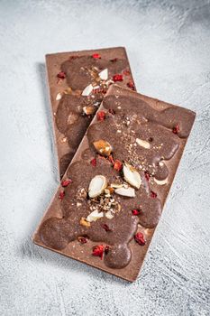 Craft homemade chocolate bars on kitchen table. White background. Top view.