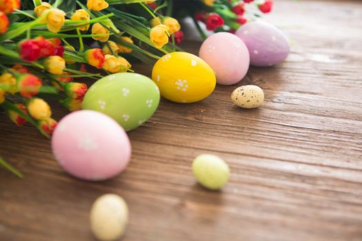 Easter eggs on wooden background. Colorful pastel easter eggs on a wooden board background .