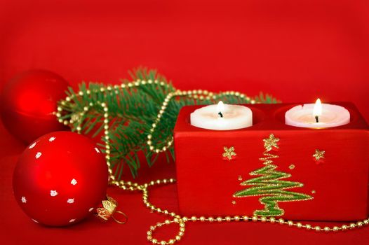 Christmas card. Candle and decoration isolated on red