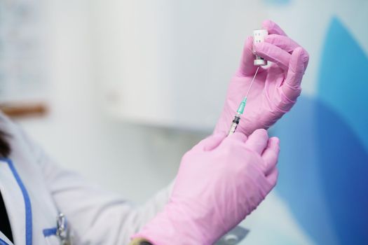 Aesthetic doctor preparing the syringe with the botulinum toxin to be injected in her patient.