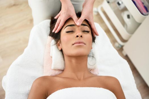 Arab woman receiving head massage in spa wellness center. Beauty and Aesthetic concepts.