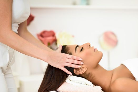 Arab woman receiving head massage in spa wellness center. Beauty and Aesthetic concepts.