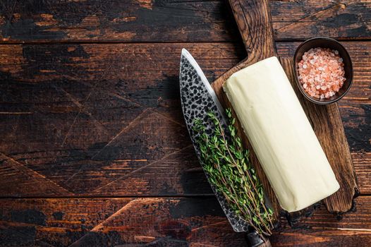 Butter Spread block on a wooden board. Dark wooden background. Top view. Copy space.