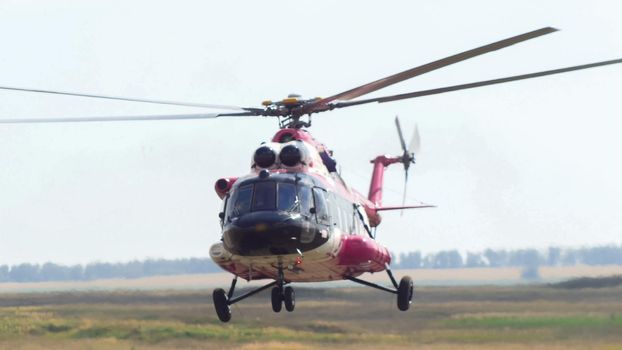 Modern emergency medicine helicopter take off at airfield, telephoto