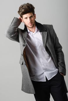 Portrait of handsome man, model of fashion, wearing coat. Studio shot