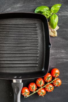 Cast iron griddle pan on black background with vegetables