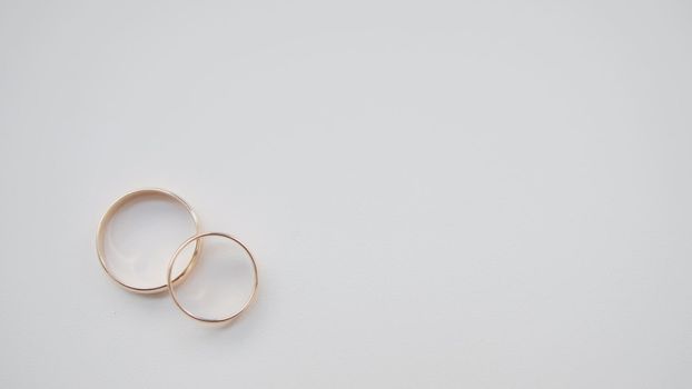 Golden wedding rings on white background, close up
