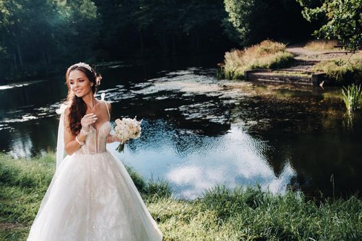 portrait of an elegant bride in a white dress with a bouquet in nature in a nature Park.Model in a wedding dress and gloves and with a bouquet .Belarus.