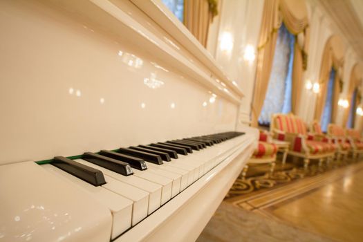 Classical Piano - white and black keys. Golden luxury ballroom, close up