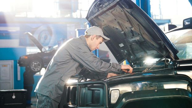 Mechanic in car service - compartment for luxury SUV, wide angle