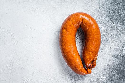 Smoked sausage on a white rustic table. White background. Top view. Copy space.