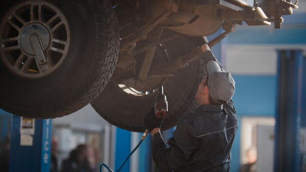 Mechanic is checking the wheel in garage automobile service, telephoto