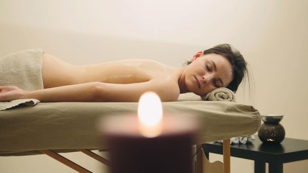 Oil relax massage - half nude young female on parlor, spa concept, close up