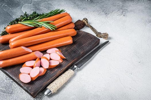German raw Frankfurter sausages on a wooden board. White background. Top view. Copy space.