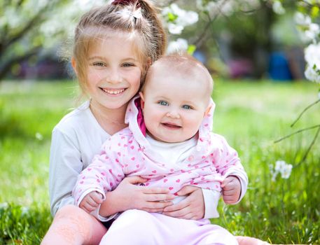 two lovely sisters in a meadow on a sunny summer day