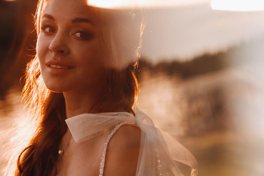 An elegant bride in a white dress enjoys nature at sunset.Model in a wedding dress in nature in the Park.Belarus.