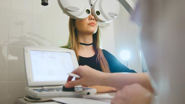 Woman doing eye test with optometrist in medical center, close up