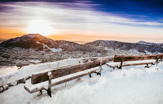 beautiful winter landscape with wooden bench from a mountain top