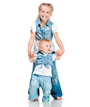 two cute sisters in the same clothes in studio isolated