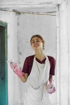 cheerful woman painter In a white apron home renovation. High quality photo