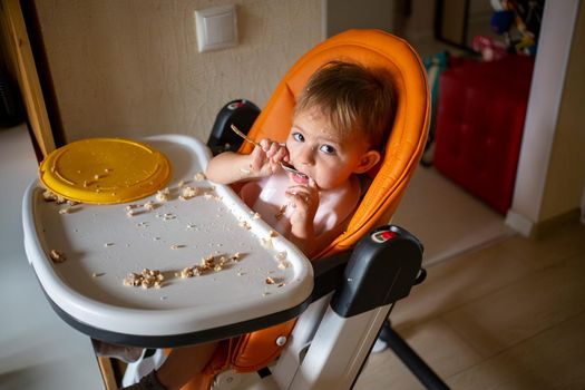 toddler baby eating dirty in the highchair at home