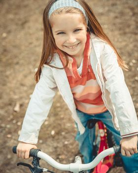 Little girl on a bicycle in summer park