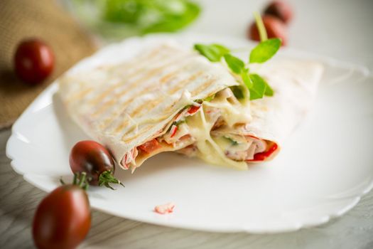 baked pita roll with filling in a plate on a wooden table