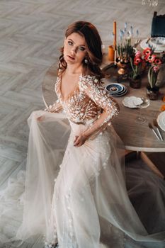 A luxurious bride in a wedding dress in the morning in her interior.