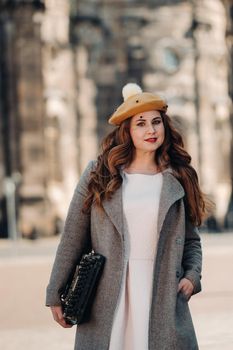 a beautiful girl in a hat stands with a typewriter in the Old city of Dresden.Germany