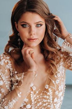 Close-up portrait of a luxurious bride in a wedding dress in the morning in her interior.